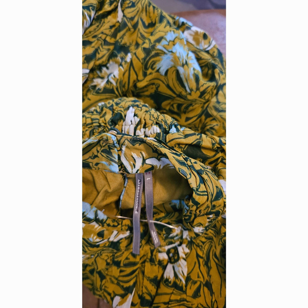 Mock-neck chiffon fabric close-up with yellow, teal, and white floral print