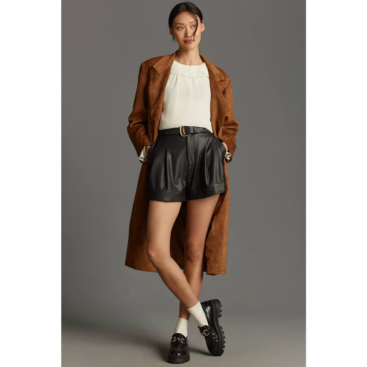 Black faux leather pleated shorts with cuffed hem and side pockets