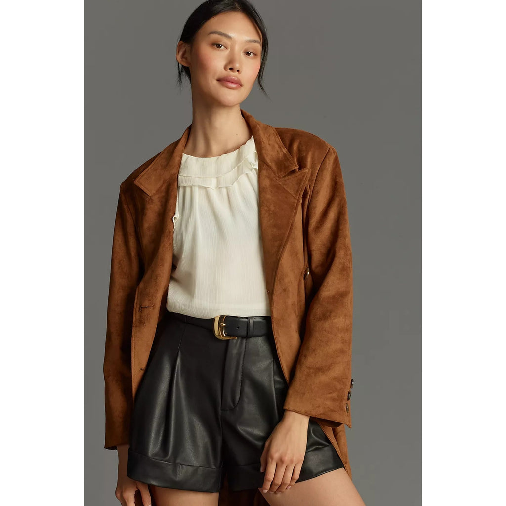 Black faux leather shorts with pleated details, belt loops, and cuffed hem