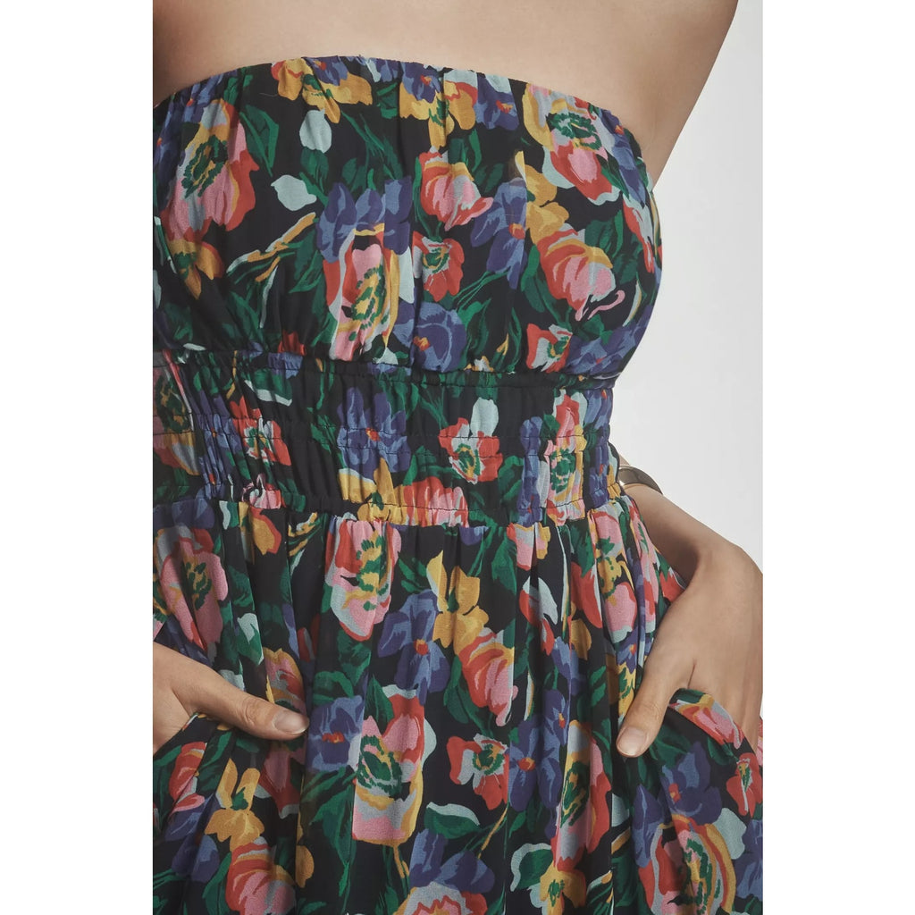 Close-up of strapless floral tiered dress with gathered smocked bodice and ruffles