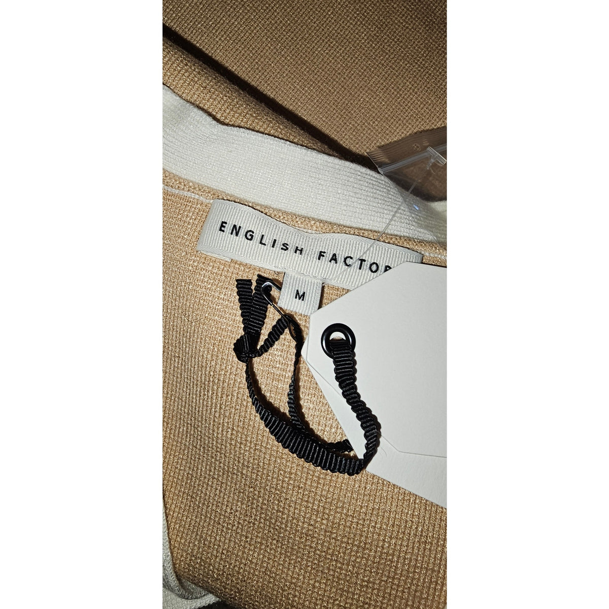 English Factory knit dress label and size tag on gold-brown fabric