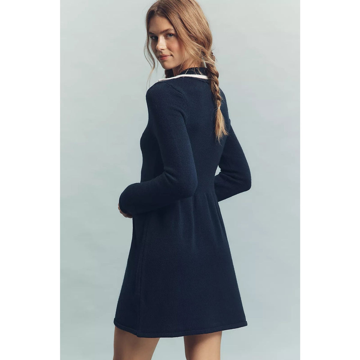 Back view of a navy long-sleeve knit mini dress with a flared skirt and white collar trim