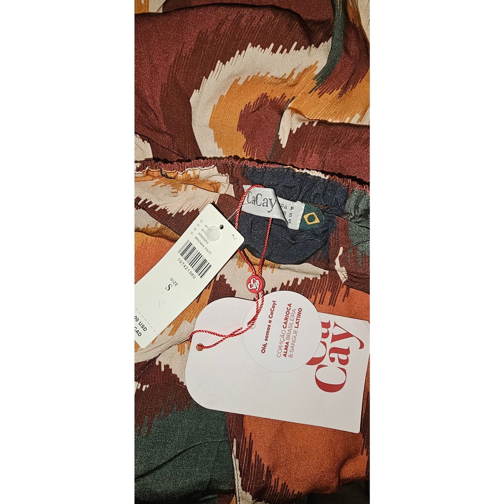 Halter-neck jumpsuit with tags on rust-brown fabric, cream and orange pattern