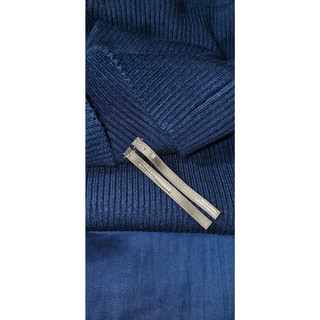 Detail of navy ribbed knit fabric with sewn label on sweater bodice