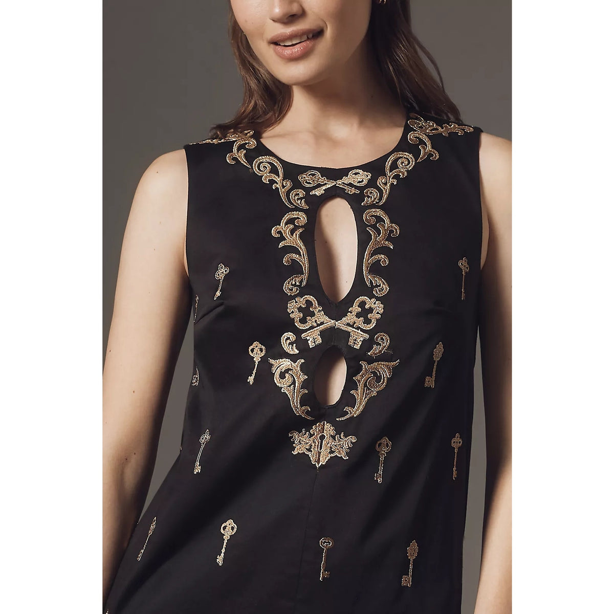 Black sleeveless mini dress with ornate gold embroidery and central keyhole cutout