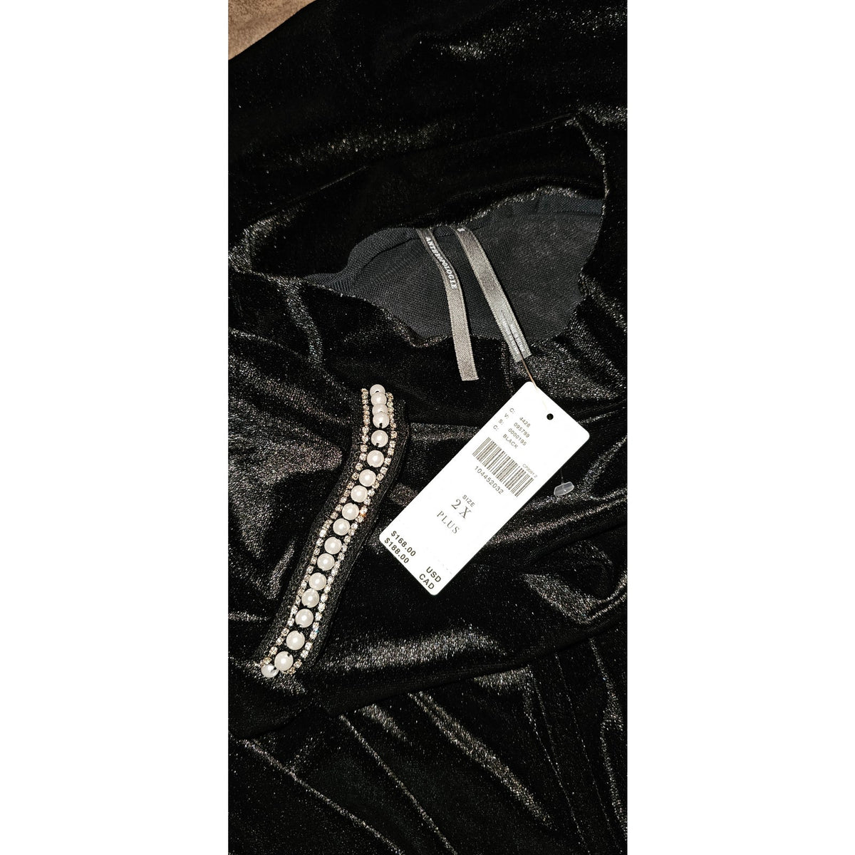 Black shiny dress fabric with rhinestone beaded trim and hanging label
