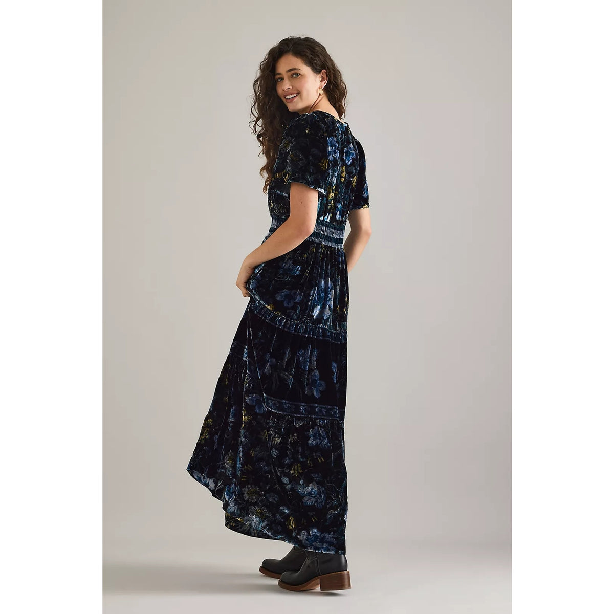 Dark blue velvet maxi dress with V-neck, short sleeves, and flowing tiered skirt