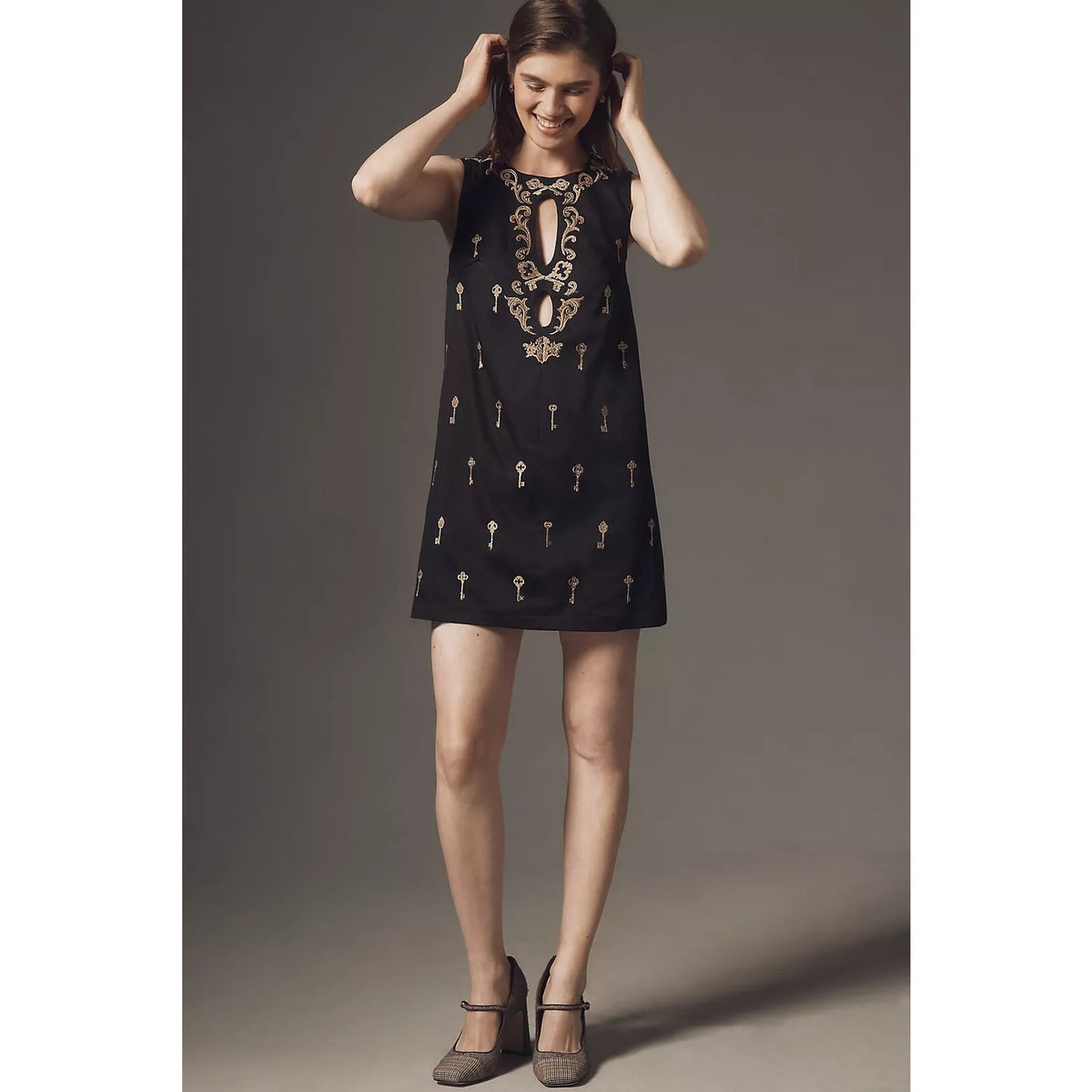 Black sleeveless mini dress with gold keyhole cutout and embroidered details