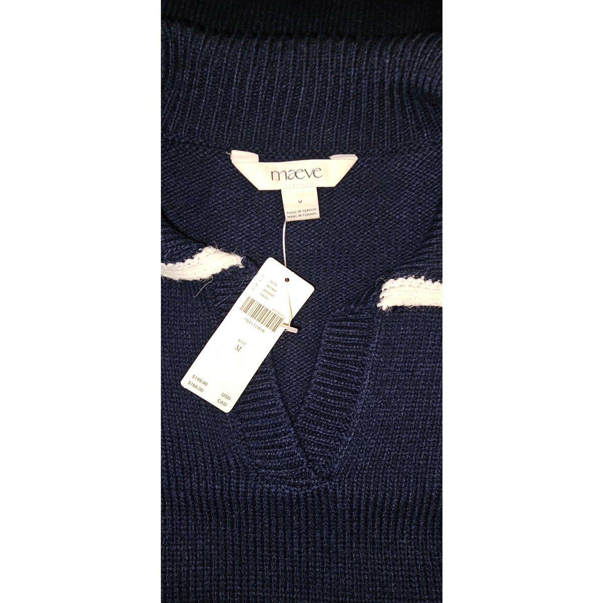 Close-up of the navy ribbed knit, white collar trim, and Maeve label.