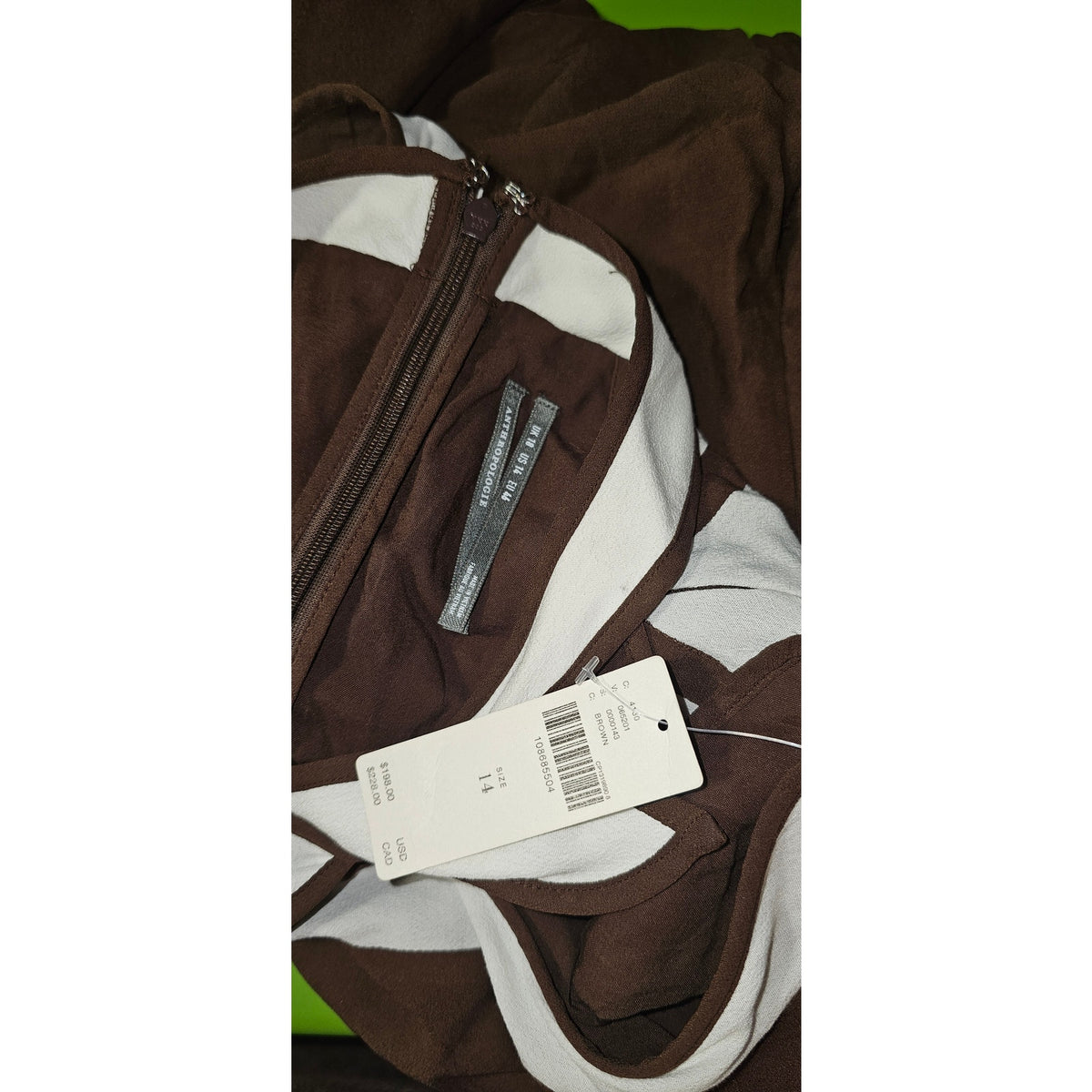 Brown maxi dress close-up with zipper pocket, white stripe trim, and size tag