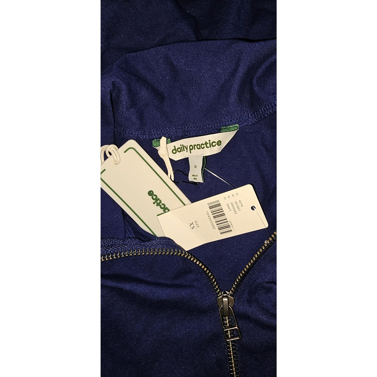Close-up of the dress label, fabric, and front zipper