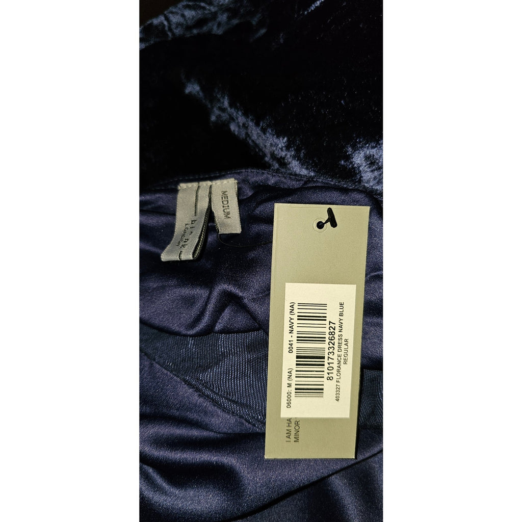Navy velvet fabric closeup with garment label and size tag