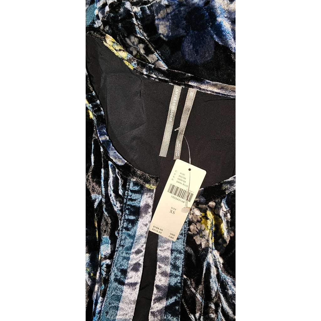 Dark blue velvet dress close-up with patterned ruffles and size label on yoke