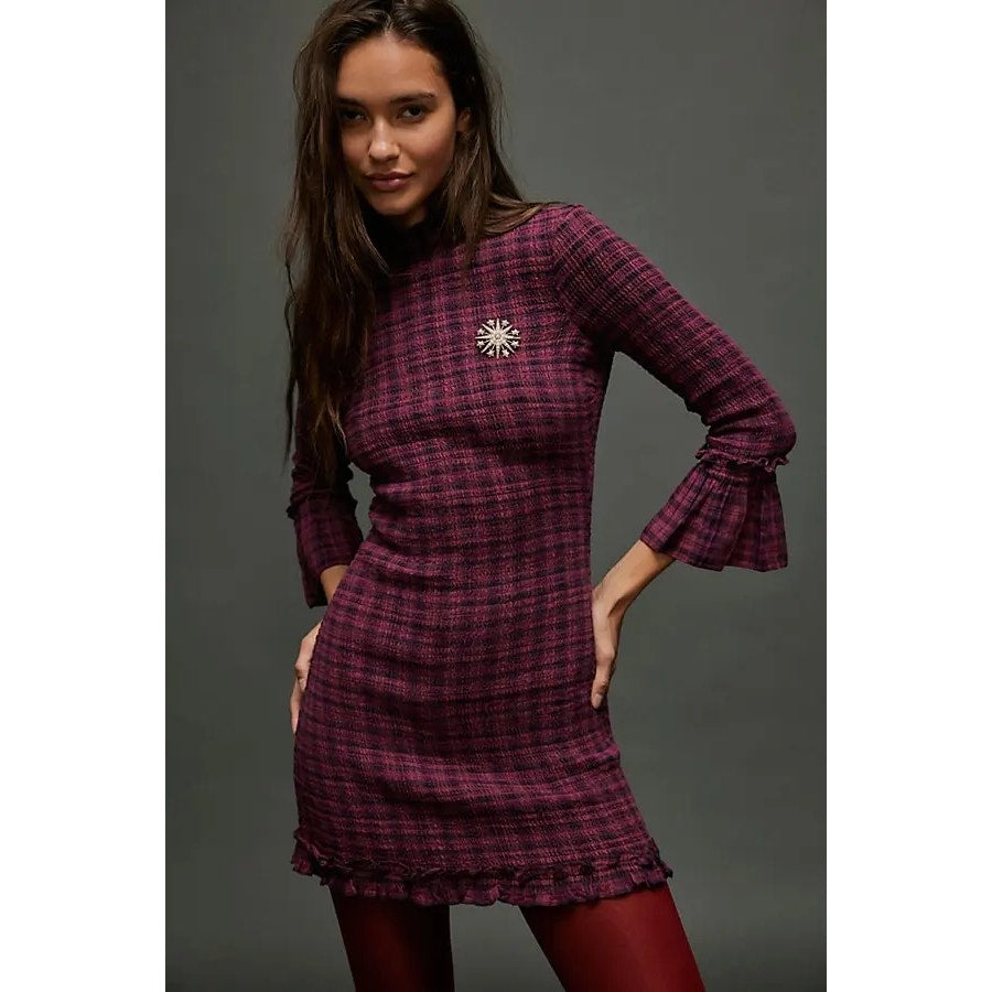 Magenta plaid mini dress with long sleeves, flared cuffs, and starburst chest detail