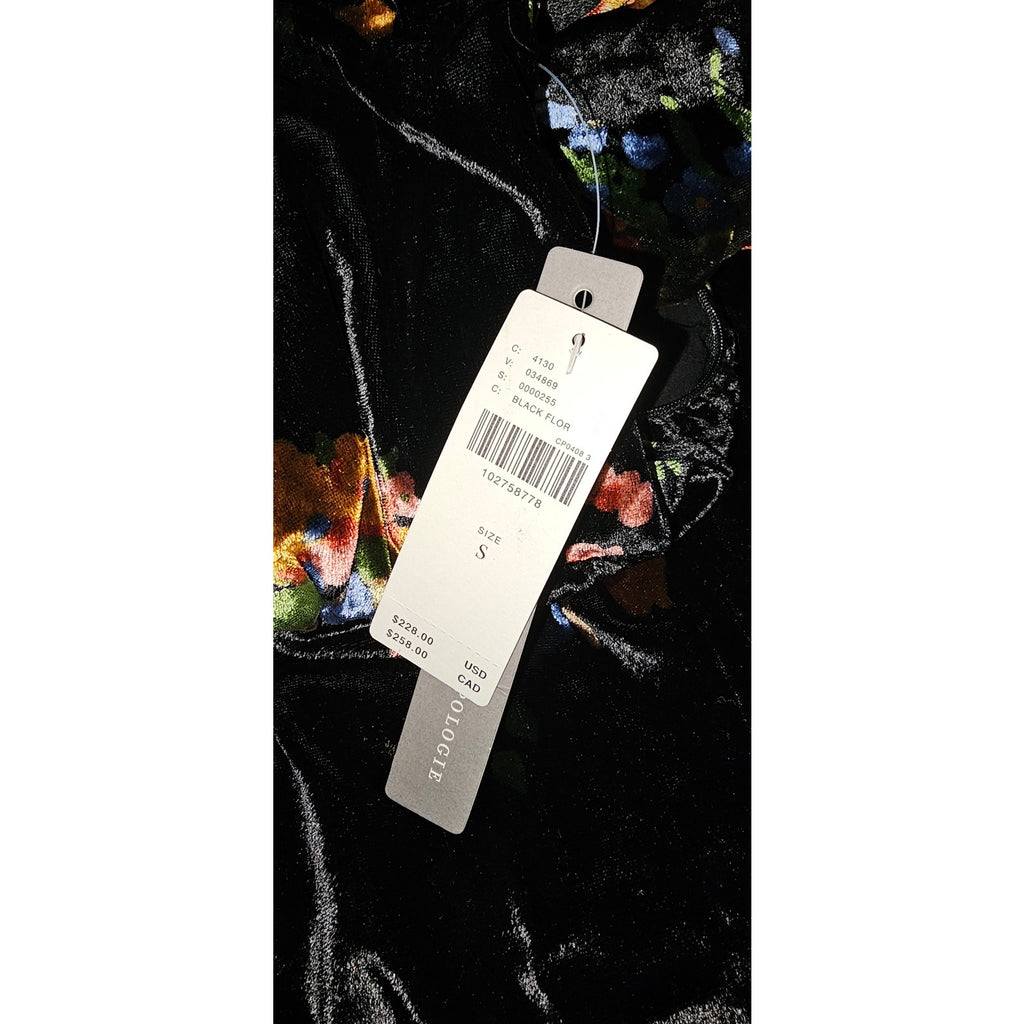 Black velvet dress fabric close-up with size and barcode product tags