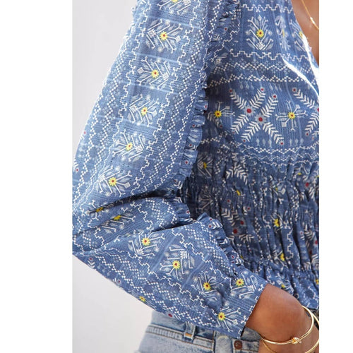Blue embroidered blouse with gathered smocked waist and long sleeves, motif detail